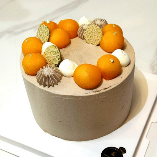 Cake decorated with oranges and white flowers on a white background