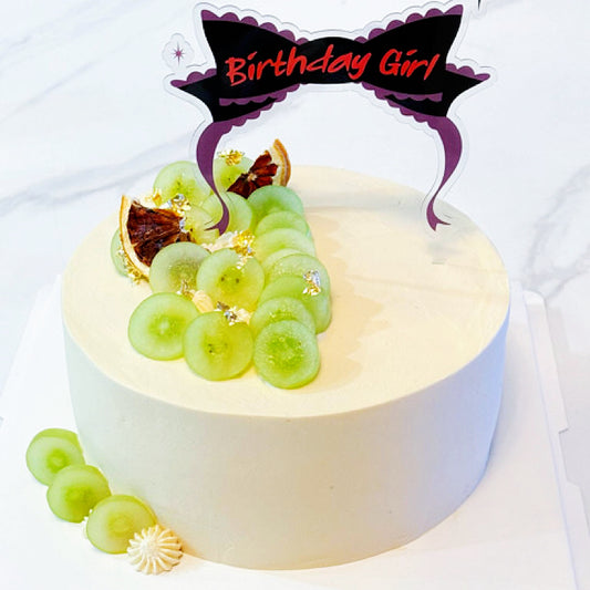 Small cake with green grapes and a decorative element on a white background