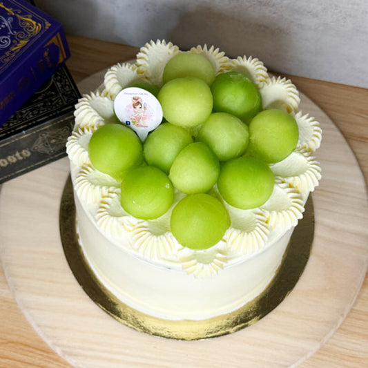 Cake with green grapes on top on a wooden table
