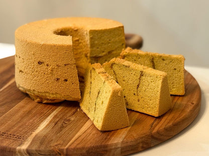 Yellow sponge cake with slices on a wooden cutting board