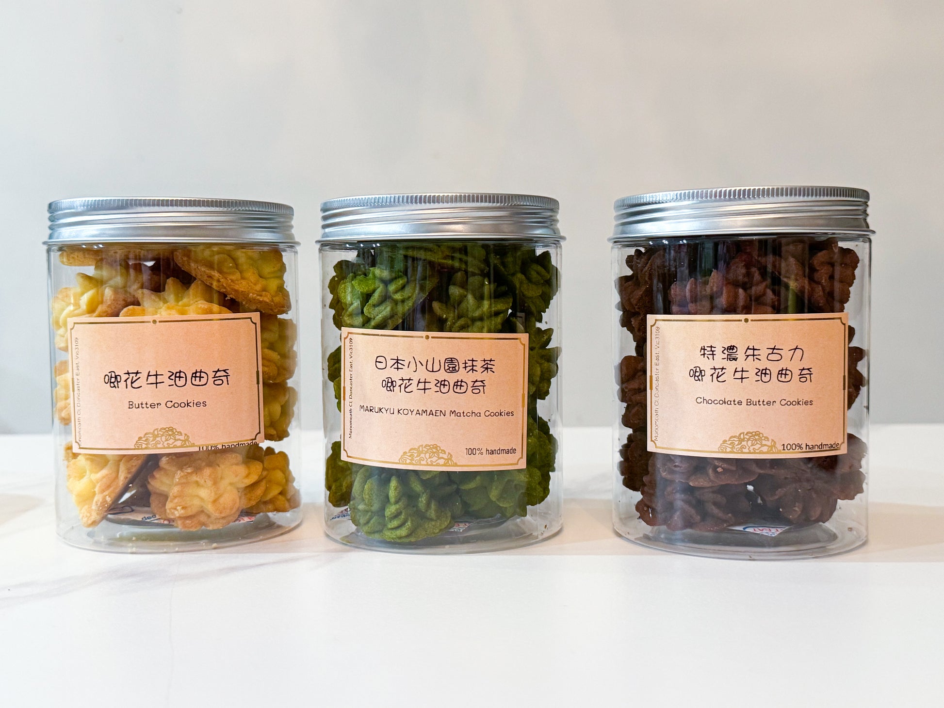 Three jars of dried fruits and nuts with labels on a white background