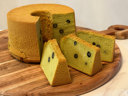 Green tea cake with slices on a wooden board